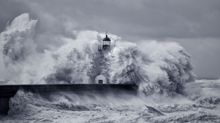 Stock massive wave hitting a lighthouse on a pier
