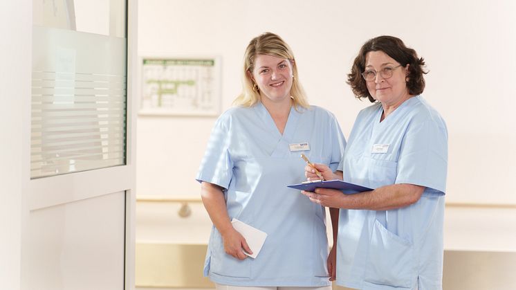 Die beiden Gesundheits- und Krankenpflegerinnen Katharina Boksgorn (links) und Carmen Weber im Stationsflur der Hephata-Klinik. (Foto: Hephata-Archiv/Stefan Betzler)