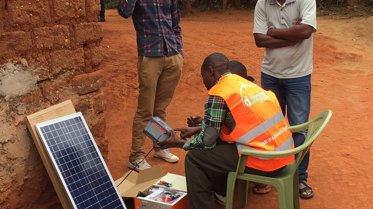 Installatör från d.light går igenom ett solar home system med en familj i utkanten av Nairobi, Kenya.