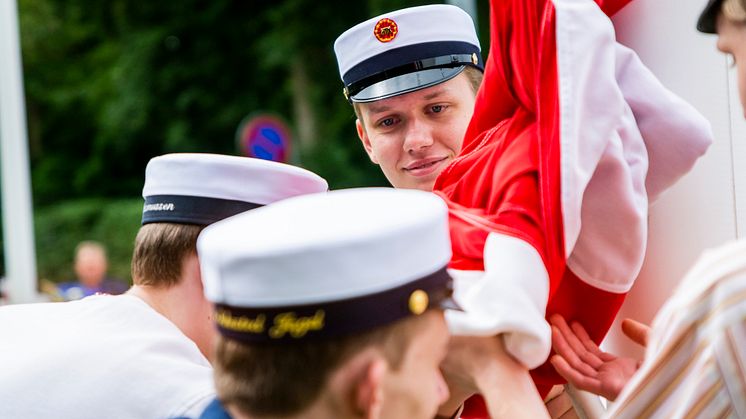 De første studenter på Tradium HTX hejser flaget foran skolen.
