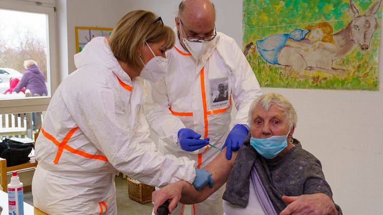 Angela Komossa und Horst Sehner vom Zentralbereich Gesundheit und Therapie (von links) der Hephata Diakonie impfen Edeltraut Stritt (84), Bewohnerin im Wohnverbund Alter Gutshof.