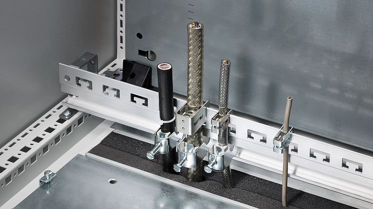 Rittals kombinerede skinne til EMC-kontakt og trækaflastning sparer tid og sikrer elinstallationen.