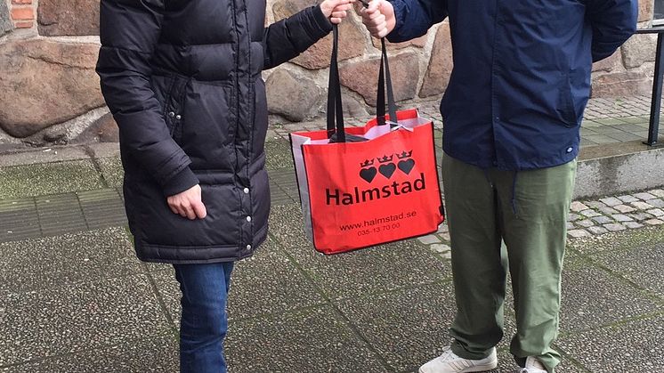 Budget- och skuldrådgivare Åsa Jacobsson delar ut den första swoppåsen till Henrik Cecerlund.