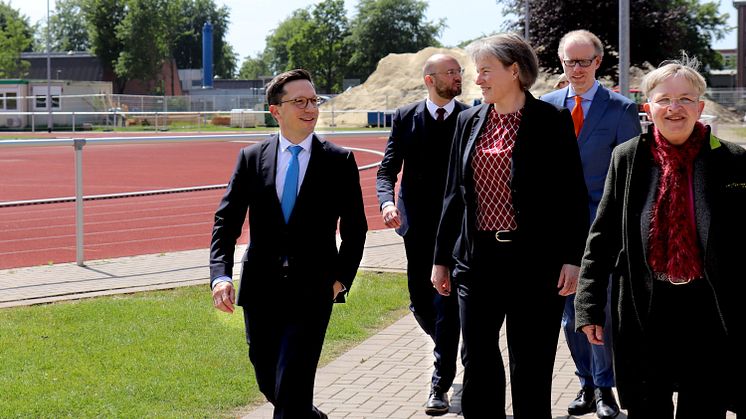 Minister Falko Mohrs (l.) beim gemeinsamen Rundgang über den Campus. Im Hintergrund ist die Baustelle für den neuen Sportcampus der Universität Vechta zu sehen. 