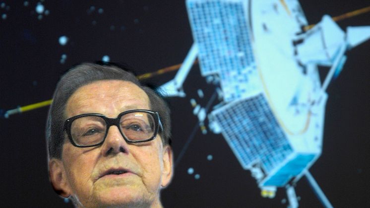 Prof. em. Bengt Hultqvist framför en bild på den första svenska satelliten Viking (uppsändning 1986) som han var en av initiativtagarna till (Foto: Torbjörn Lövgren, IRF) 