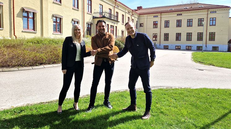Josefine Nordström, avdelningschef Lokal och Daniel Ruus, Fastighetsutvecklingschef på Eidar skakar hand med Arvin Yarollahi, VD och verksamhetschef för Specialistläkarna. Stavregården i bakgrunden ska byggas om till center för specialistvård.