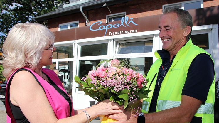Danke für die Unterstützung: Mit Blumen überrascht SH Netz-Projektleiter Torsten Carstensen Friseurmeisterin Maren Hoffmann, die wie viele Anwohner und Gewerbetreibende großes Verständnis für die Einschränkungen während der Gas-Baumaßnahme zeigte.