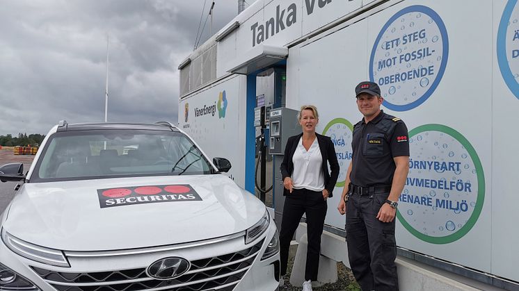 Securitas första vätgasbil, redo att patrullera på vätgas i Mariestads kommun. Något som Niklas Samuelsson påpekar är ett steg för att sänka Securitas koldioxidutsläpp. Här tillsammans med Susanné Wallner, Näringslivschef Mariestads Kommun.