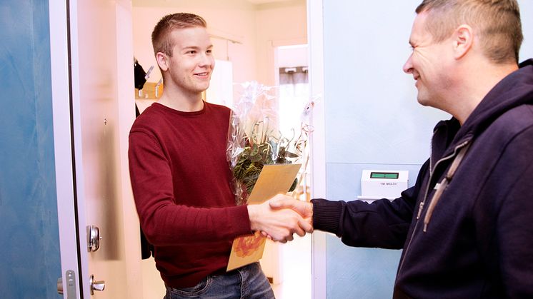 Studenten Tim Midlöv svarade på enkäten Nöjd Studbo och vann utlottningen av en månadshyra. Kvartersvärd Ian Pearson gratulerar.