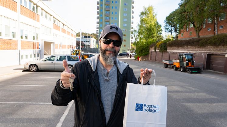 Karim har hämtat nycklarna och ser fram emot att få flytta in i sitt nya moderna hem. I bakgrunden syns det nya huset.