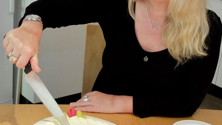 Heléne Karlsson skär tårtan