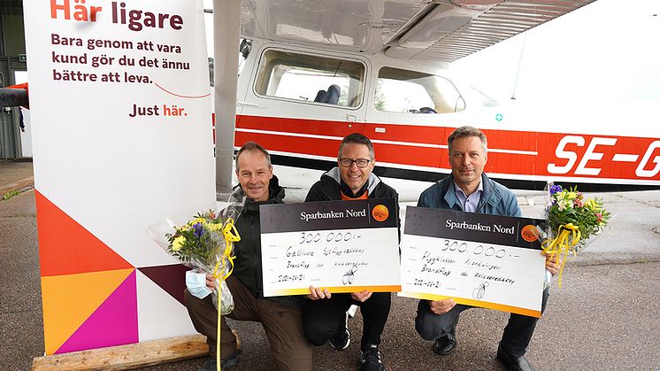 Robert Nilsson, Gellivare flygsällskap och Thomas Wettainen, Flygklubben Nordvingen mottar check och blommor av Jörgen Svonni, Sparbanken Nord (mitten). Foto: Mats Hillblom