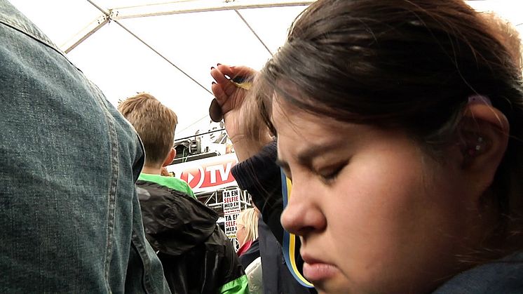 Viktoria Valverde delar ut en  "Störd och stolt" medalj till Amat Levin i Almedalen.