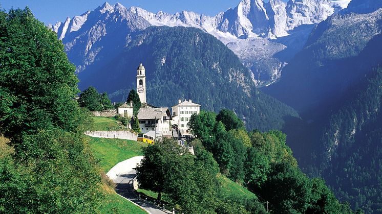 Postauto im Kanton Graubünden: das Dorf Soglio im Bergell, im Hintergrund die Sciora-Bergkette.  © Die Post/Schweiz Tourismus (ST/swiss-image.ch)