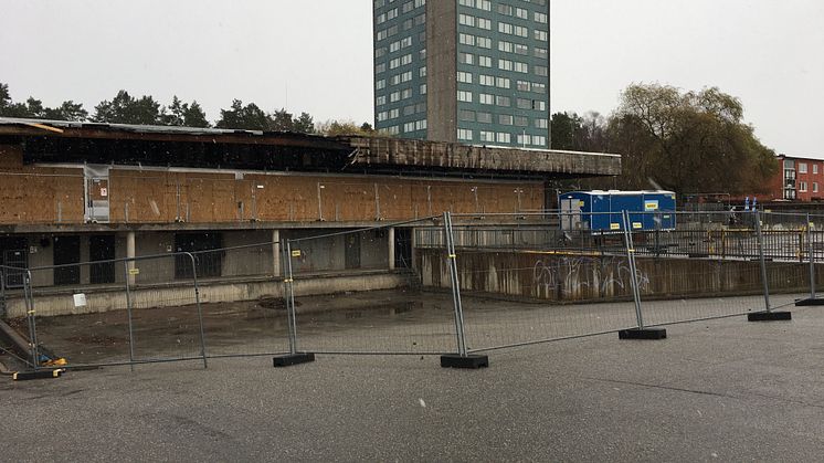 Staket runt det eldhärjade Bjurhovda centrum som nu ska rivas.