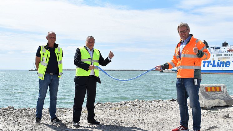 Jörgen Nilsson, vd Trelleborgs Hamn och Patrik Magnusson, ombud Peab Anläggning AB gör ett Corona-handslag efter kontraktskrivning. T v Ulf Sonesson, Landlordchef, Trelleborgs Hamn