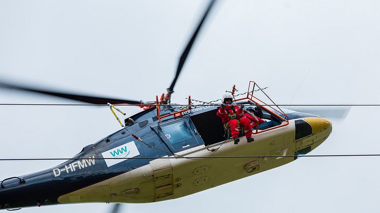 Präzisionsarbeit für alle Beteiligten: Reparaturen an Blitzschutzseilen auf Hochspannungsmasten.