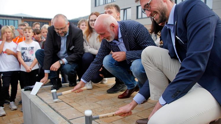 Landrat Daniel Kurth (v.l.), Schulleiter Mafred Reinicke und Bürgermeister Maximilian Wonke verlegen symbolisch die letzten Pflastersteine. Foto: Pressestelle LK Barnim/Oliver Köhler