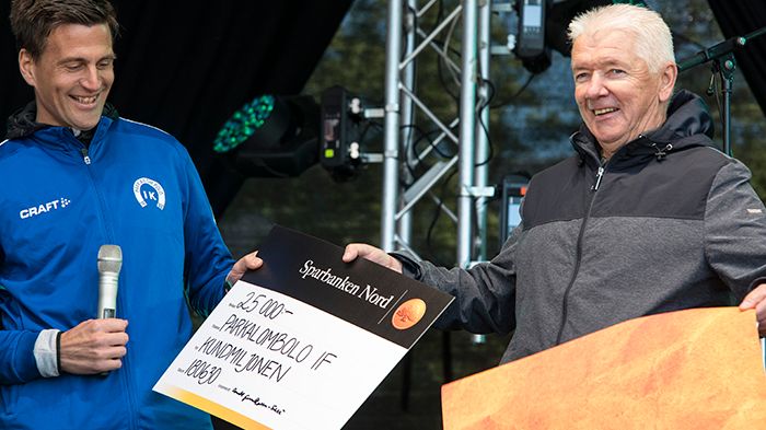 Tänare Marcus Jönsson Åberg tar emot Donald Gunillassons del av Kundmiljonen för Parkalompolo IK:s räkning.