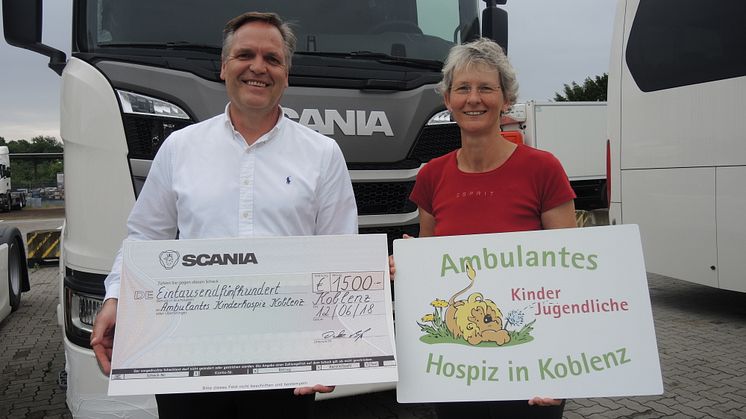 Detlev Both, Mitglied des Betriebsrats von Scania Deutschland, überreicht den Spendenscheck in Höhe von 1.500 Euro an Ute Bohnstengel vom ambulanten Kinder- und Jugendhospiz in Koblenz.