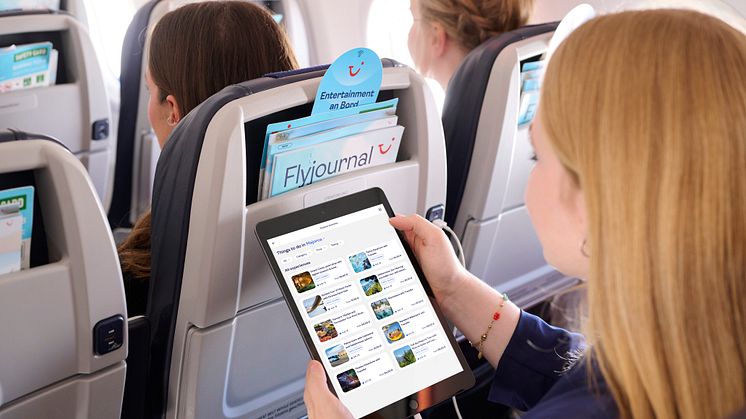 Matkustaja käyttää tabletia lennolla; istuintaskussa Flyjournal-lehti ja digitaalinen  viihdetarjonta 