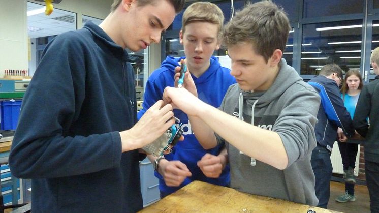 WWE- Azubi Mark Hindersen, Jonas Oehler und  Raphael Kolax von der Gesamtschule Rödinghausen  bauen einen Mini-Roboter in der Ausbildungswerkstatt in Kirchlengern (v. l.).