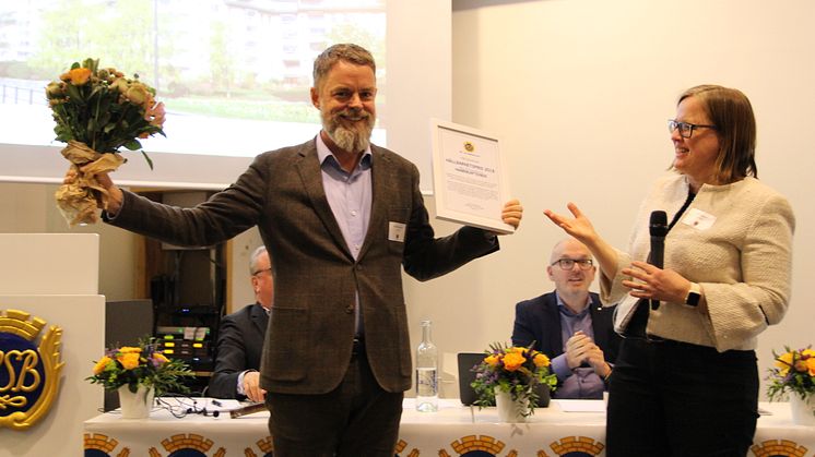 David Samuelsson, ordförande i HSB brf Hamnkaptenen på Södermalm, tar emot 2018 års hållbarhetspris från HSB Stockholms styrelseordförande Jenny Hjalmarsson. 
