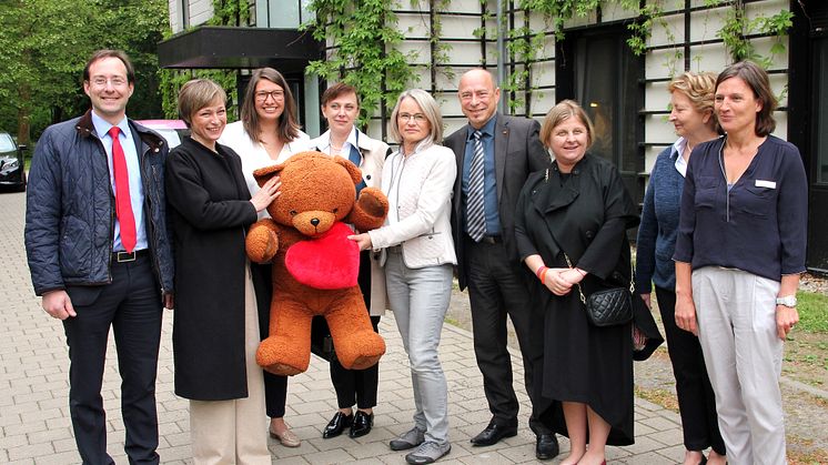 Hubertus Freiherr von Erffa, Maka Chichua, Ulrike Herkner, Dali Chanturia, Sigrid Magnus, Thomas Feist, Nina Kikandze, Ulrike Wesner und Sylvia Heumann vor dem Kinderhospiz