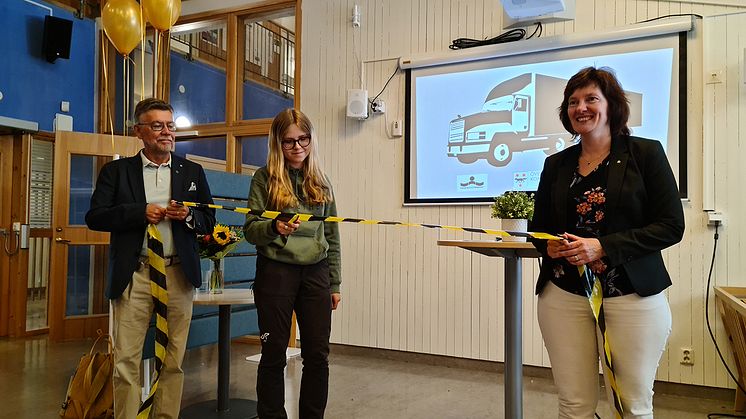 Åk 1  eleven Edith Jauhiainen (i mitten) fick klippa invigningsbandet som symbol för att transportprogrammet nu finns som inriktningsval. I bild Börje Rytiniemi, barn och utbildningsnämndens ordförande och till höger tf. skolchef Katarina Lindberg.