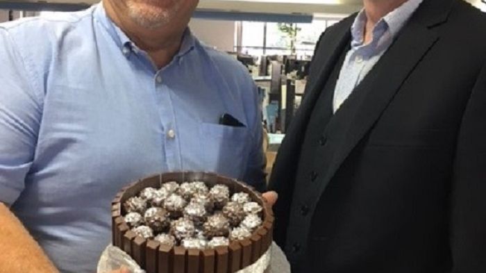 Mike Evans, Fred. Olsen’s Head of Sales (left), receives his celebratory 25th anniversary cake from Justin Stanton, Sales and Marketing Director, at Fred. Olsen House in Ipswich, Suffolk 