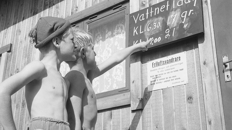 Röda Korsets stuga vid Lill-Olas. Två pojkar kollar vattentemperaturen.© Sandgren-Petersson, 1952.