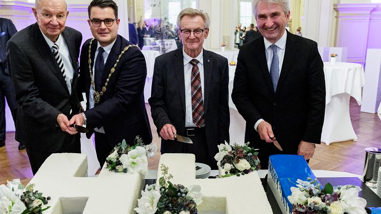 Anschnitt der Jubiläumstorte (v.l.n.r.: Alt-Rektor Prof. Dr. Dr. h.c. mult. Heribert Meffert, Prof. Dr. Tobias Dauth,  Alt-Rektor Prof. Dr. rer. pol. habil. Hans Wiesmeth, Alt-Rektor Prof. Dr. Andreas Pinkwart)