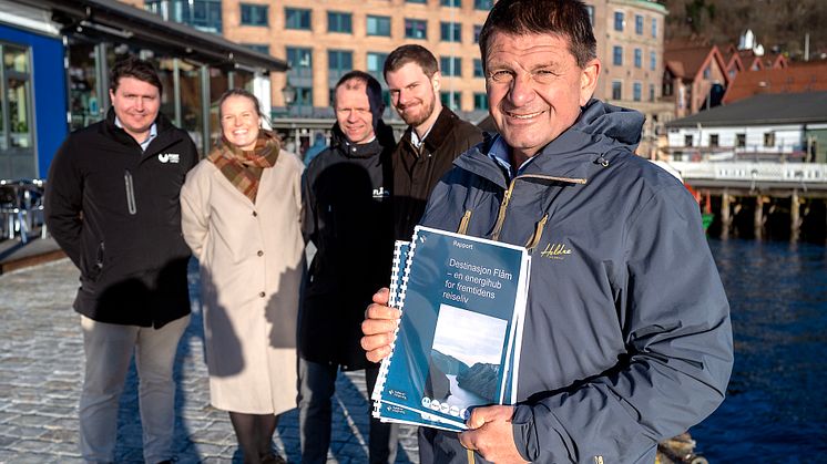 Ordførar i Aurland, Trygve Skjerdal visar stolt fram rapporten om den nyskapande energiløysninga. I bakgrunnen ser du delar av prosjektgruppa, frå venstre: Tor Mikkel Tokvam, Tale Marie Astad Paulshus, Arve Tokvam og og varaordførar David Underdal.
