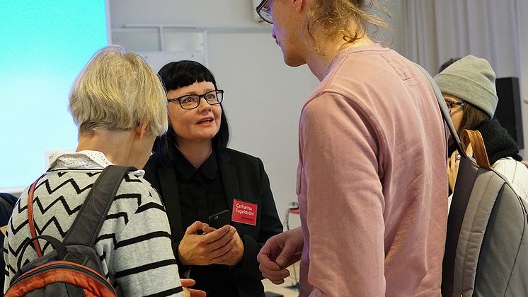 Catharina Fogelström, enhetschef för kultur- och föreningsstöd på Stockholms läns landstings kulturförvaltning på kulturförvaltningens Öppet hus om nya stöden. Foto: K.Wikström. Syntolkning: Catharina samtalar med två personer. 