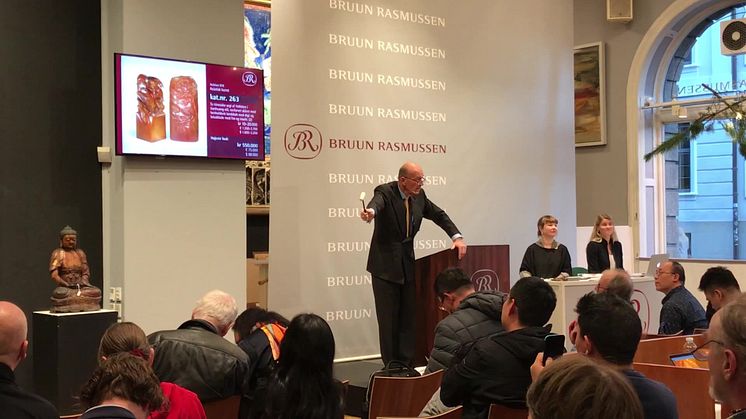 Jesper Bruun Rasmussen svinger hammeren over to udskåret fedtstensfigurer