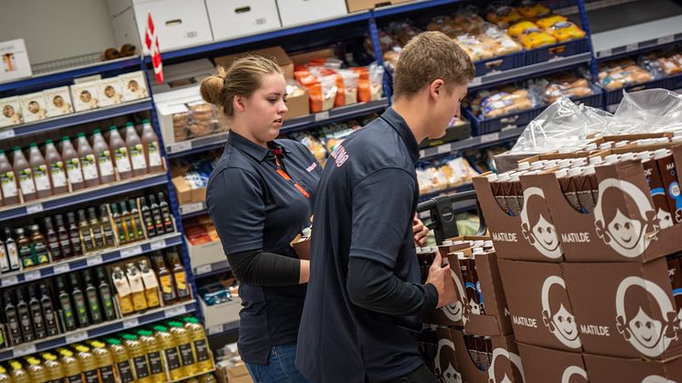 Michelle og anden elev fylder varer op.