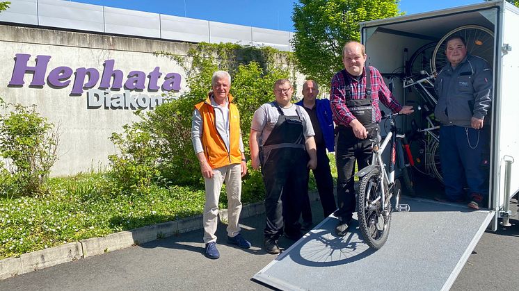 Klaus Molis vom ADFC (von links) nimmt den Anhänger von Lukas Schwarzbach, Arbeitsgruppenleiter Jochen Trümner, Matthias Geisel und Tobias Drescher in Empfang. 