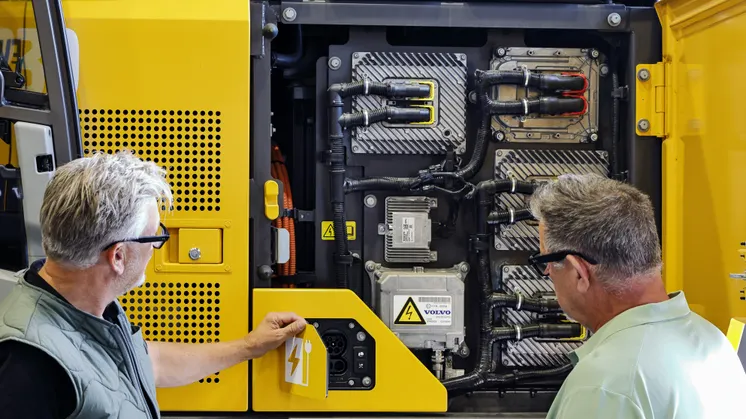 Säljare Jonas Rosvall öppnar luckorna till Östuna Maskins Volvo EC230 Electric.