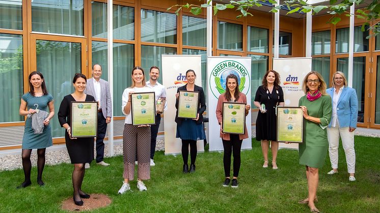 dm-Geschäftsführerin Kerstin Erbe (in Grün) mit den Kolleginnen und Kollegen der dm-Marken-Teams und Norbert Lux (graues Jacket) bei der Übergabe des GREEN BRANDS Gütesiegel.