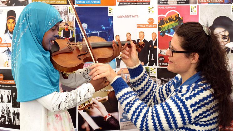 Sångaren och violinisten Åsa Håkansson visar hur man spelar fiol, foto: Marika Yamoun