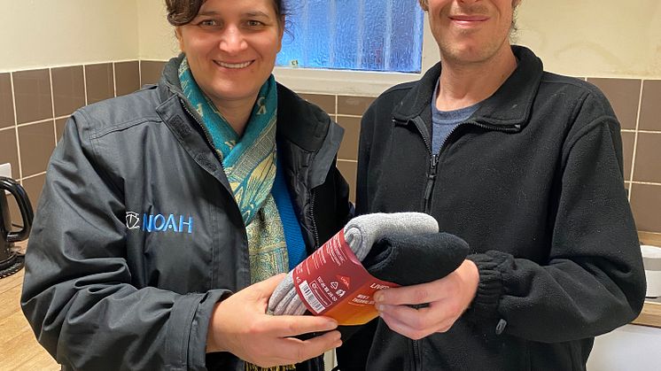 NOAH Enterprise's Outreach Team member Nela Mazilu hands over socks to one of the charity's clients. 