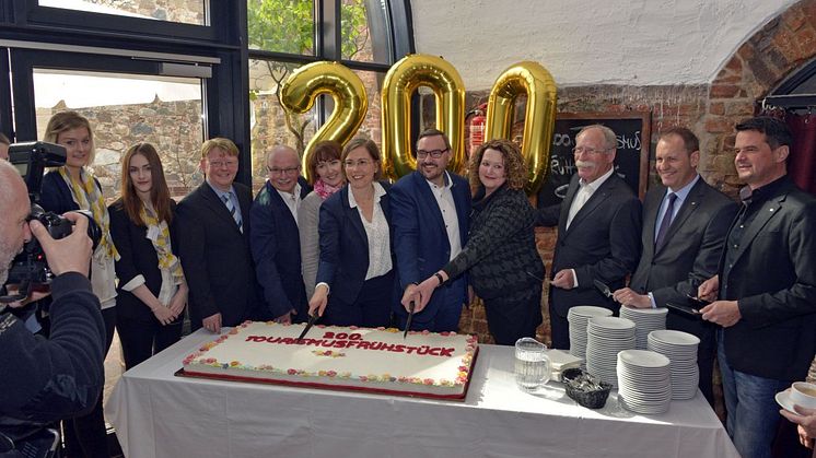 Kulturbürgermeisterin Dr. Skadi Jennicke (m.) und Gäste der ersten Stunde schneiden die Jubiläumstorte zum 200. Tourismusfrühstück an.