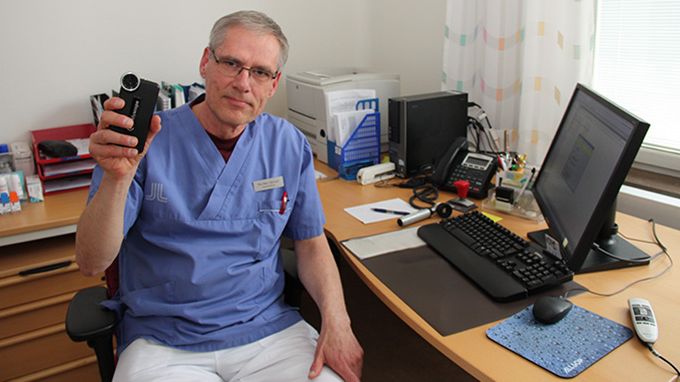 Per-Åke Tjärnvall, distriktsläkare på Norrtälje norra vårdcentral, visar instrumentet som fästs direkt på en smartphone.