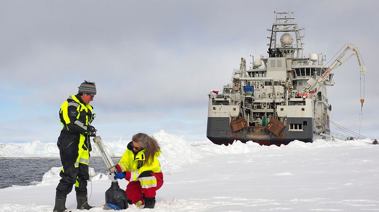 Eva Leu og Angelika Renner tar vannprøver i Polhavet på jakt etter isalger. I bakgrunnen forskningsskipet Kronprins Haakon. (Foto: Ann Kristin Balto / Norsk Polarinstitutt)