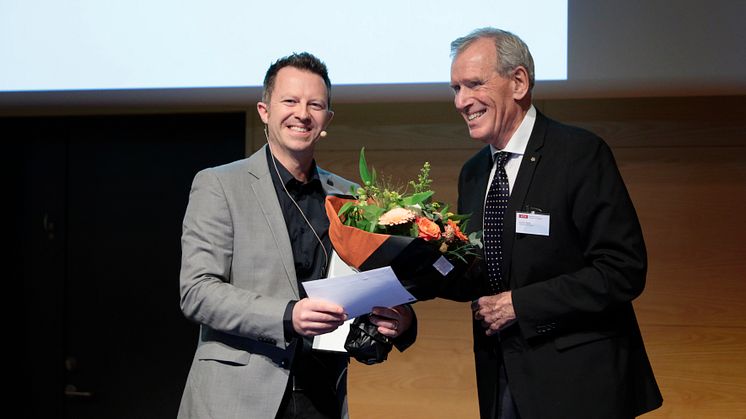 Formand for Torkil Holm priskomitéen Klaus Bock overrækker prisen til lektor Thomas Poulsen fra Aarhus Universitet (foto: Tom Jersø)