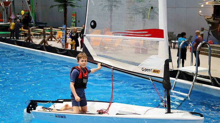 Kleine Wassersportfans lernen beim Jollensegeln die ersten Schritte