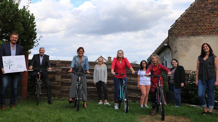 Thomas Blum, Christoph Metternich und Beate Schumacher von der Allianz freuen sich mit Josephine, Samantha und Elaine und den Mitarbeiterinnnen der Wohngruppe in Elz um Gruppenleiterin Stefanie Kück (von links) über die neuen Fahrräder.