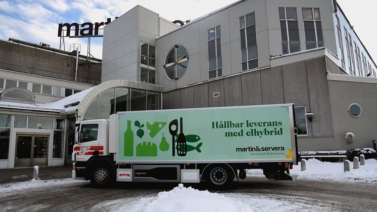 Den nya elhybridlastbilen utanför Martin & Serveras entré i Årsta