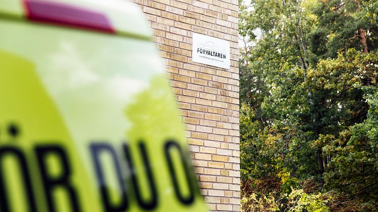 Fasad med Förvaltarenskylt och skåpbil i förgrunden