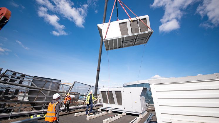 Preparatory work began in early February, with the ASHPs lifted six stories onto the roof of each building